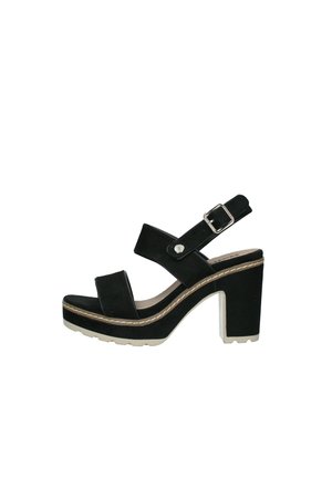 Sandales plateforme noires avec un talon épais, présentant une texture veloutée, des lanières larges, une fermeture à boucle et des coutures blanches contrastantes.