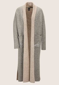 Langer grauer Cardigan mit beigem Besatz, der vorn Taschen mit kleinen silbernen Verzierungen hat.