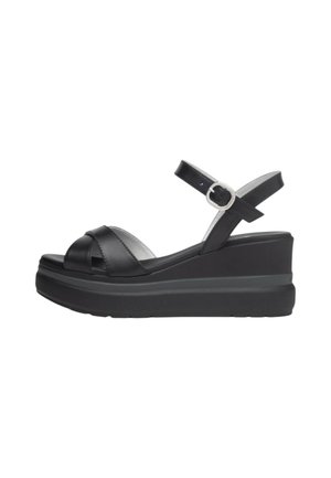 Sandali wedge neri in pelle con design a fascia incrociata, cinturino alla caviglia regolabile e suola piattaforma testurizzata. Presenta un accentuato con fibbia argentata.
