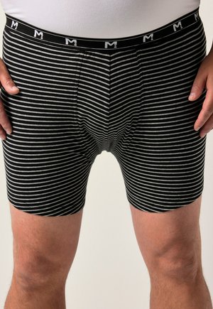 Bóxer de rayas en negro y gris con una cinturilla negra que presenta una marca en blanco. La tela parece suave y con un ajuste ceñido.