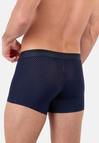 Boxer brief navy con piccole pois bianchi, dotati di una vita elastica con l'etichetta "HOM". Tessuto morbido con una texture liscia.