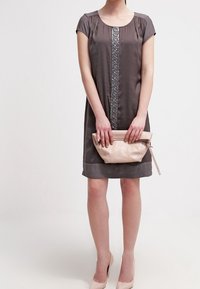 Vestido gris de manga corta con un adorno vertical decorativo; sosteniendo un bolso de mano rosa claro; textura suave, hasta la rodilla.