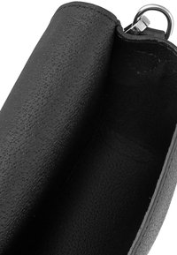 Portafoglio in pelle nera con superficie texturizzata, aperto per mostrare l'interno. Presenta un anello in metallo argentato. L'interno è liscio e di colore scuro.