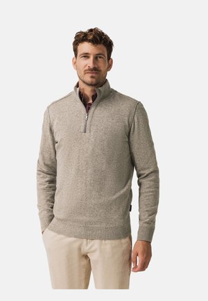 Grijze, lichtgewicht pullover met een kraag met een kwart rits, geribbelde manchetten en zoom. Gedragen over een bordeauxrode overhemd met kraag.
