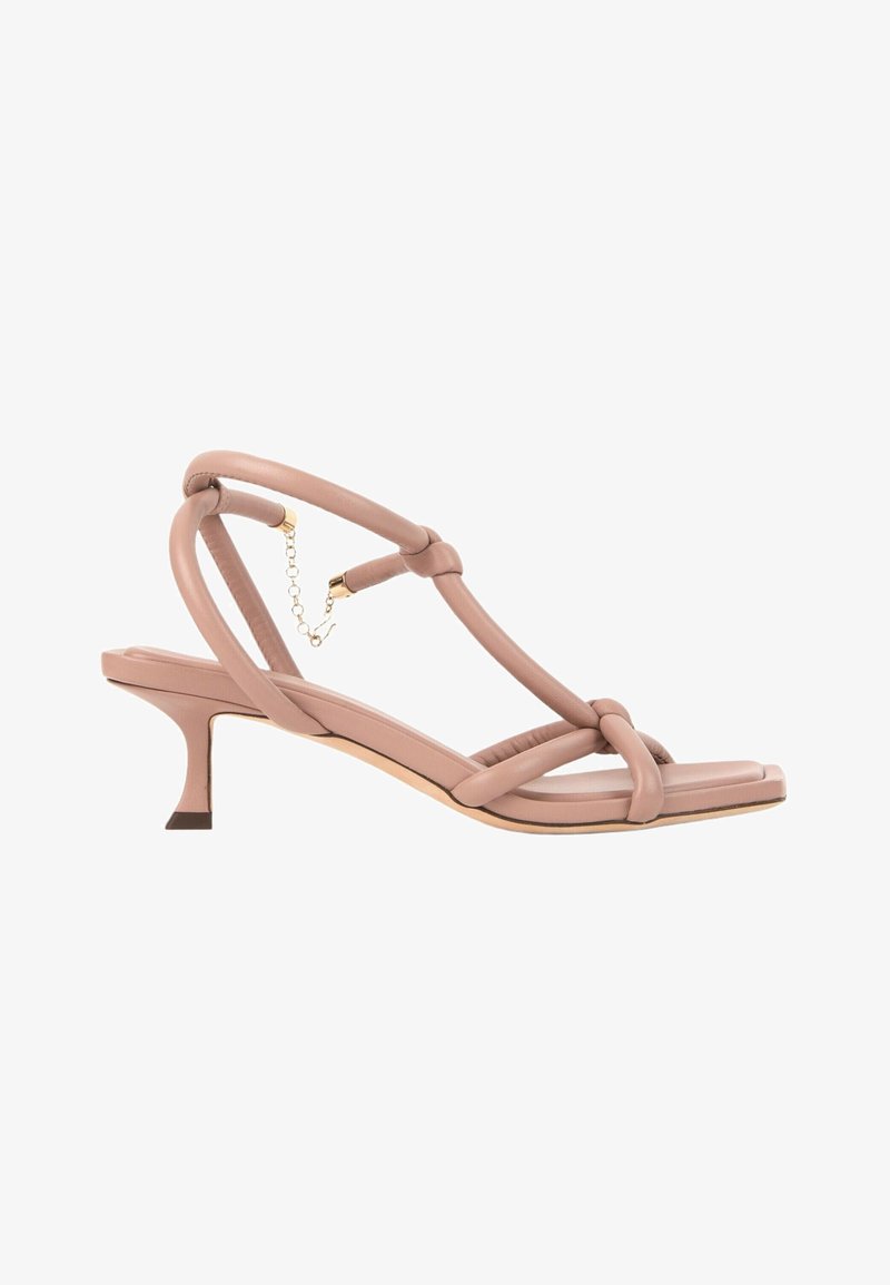 Sandale à talon haut beige nude avec brides rembourrées nouées, bout carré, petit talon kitten et fermoir cheville chaîne dorée.
