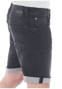 Shorts in denim nero con risvolti grigi chiari. Le caratteristiche includono tasche posteriori e una patch in pelle con il marchio sulla vita.