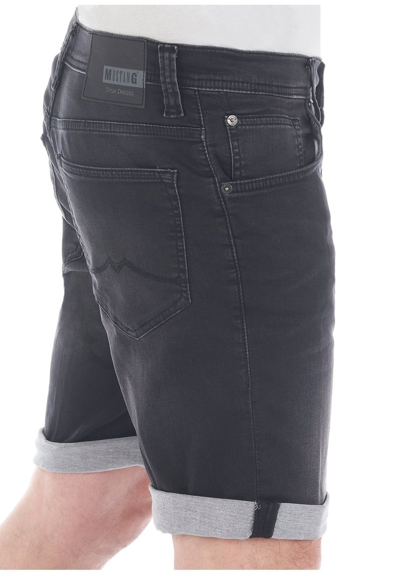 Shorts in denim nero con risvolti grigi chiari. Le caratteristiche includono tasche posteriori e una patch in pelle con il marchio sulla vita.