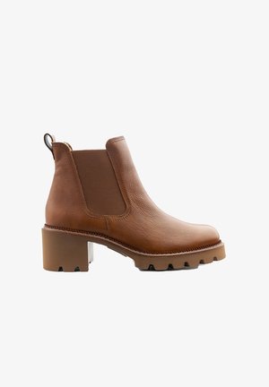 Brauner Leder-Stiefelette mit elastischen Seitenteilen. Robuste, gezackte Sohle und abgerundete Spitze. Verfügt über eine Zuglasche an der Rückseite für einfaches An- und Ausziehen.