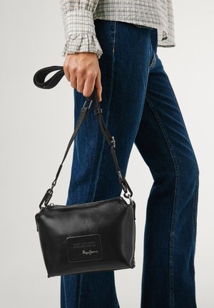 Schwarze Lederhandtasche mit glatter Textur, rechteckiger Form, abnehmbarem Tragegurt und geprägtem Logo-Detail auf der Vorderseite.