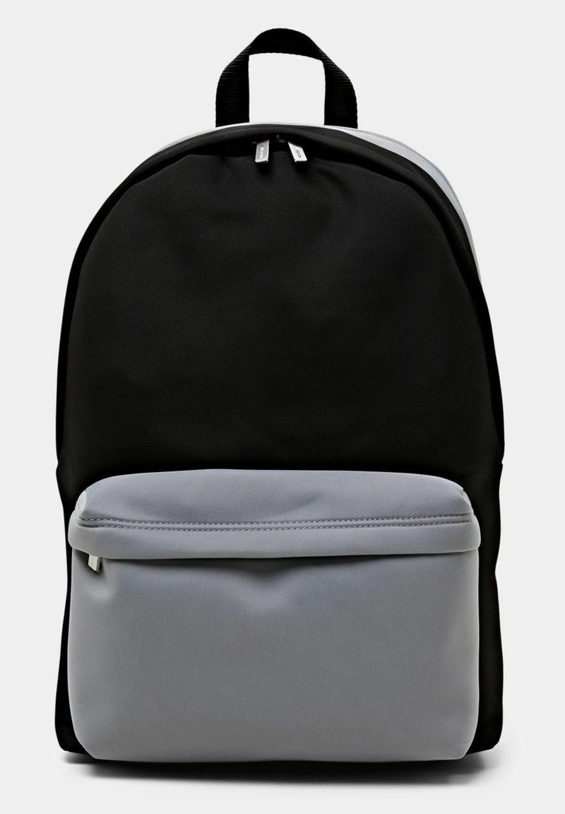 Mochila negra con un gran compartimento principal y un bolsillo delantero con cremallera en tejido gris claro, que cuenta con tiradores de cremallera dobles y un asa superior para llevar.