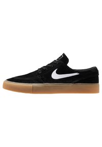Scarpe da skate in suede nere con il logo Nike bianco, suola in gomma naturale, design a profilo basso e chiusura con lacci. Dettagli sulla superficie texturizzati.