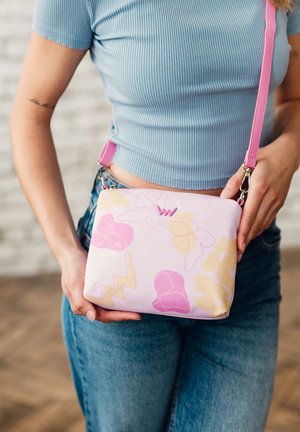 Kompakte Schultertasche im pinken Blumenmuster mit glatter Textur, ausgestattet mit hellgelben Akzenten und einem abnehmbaren pinken Schulterriemen.