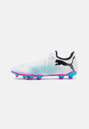 Bottes de football avec une tige en mesh blanche, logo noir et semelle vibrante bleue et rose. Équipées de crampons moulés pour l'adhérence.