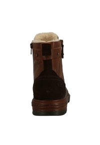 Bottine en cuir marron avec des accents en daim, doublure intérieure en peluche, fermeture éclair latérale et semelle en caoutchouc texturée. Dotée d'un bout arrondi.