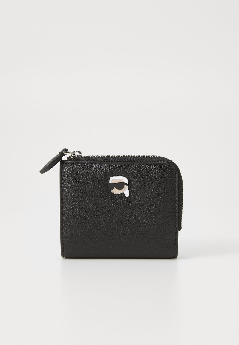 Μαύρο δερμάτινο πορτοφόλι με υφή, κλείσιμο με φερμουάρ και ασημένια λεπτομέρεια με καρτούν στο μπροστινό μέρος. Σ�υμπαγής, ορθογώνιος σχεδιασμός.