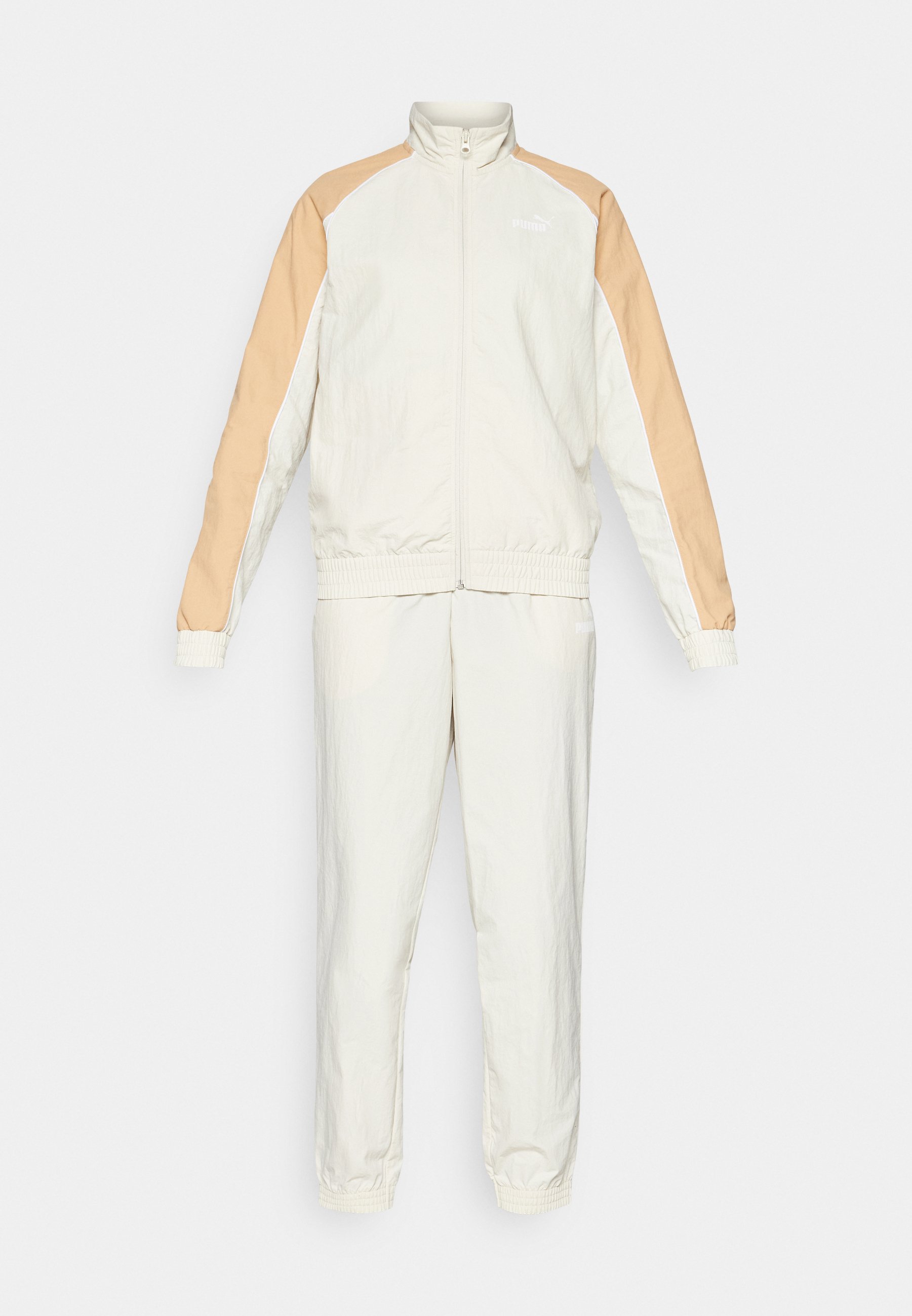 Conjunto de chándal en color blanco roto y beige. Incluye una chaqueta con cremallera y cuello alto, puños elásticos y pantalones a juego con cintura elástica.