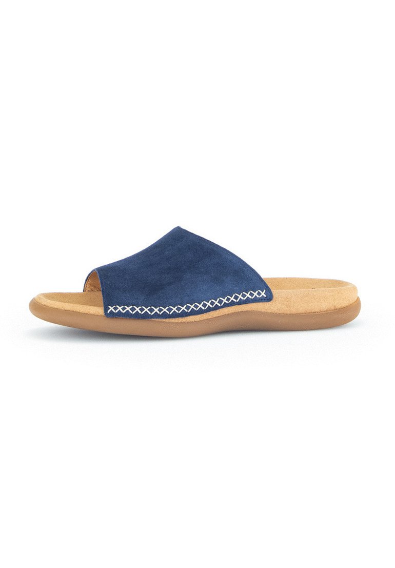Navy blue suede slide sandal with open toe, beige cushioned footbed, and white decorative stitching along the edge. Flat rubber sole.