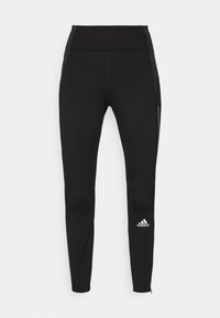 Czarne legginsy sportowe o dopasowanym kroju, z kontrastującymi ciemnymi panelami bocznymi, wysokim stanem i małym białym logo na dolnej części nogawki.
