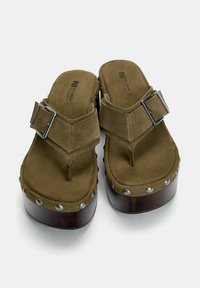 Brown suede platform sandals with a thick wooden sole, silver studs around the edges, and a metal buckle on the strap.