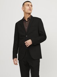 Black blazer with a single button, notched lapels, and front pockets, paired with a dark brown button-up shirt, tailored fit.