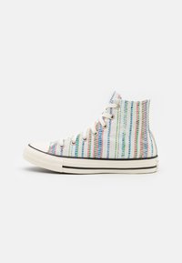 Zapatillas altas de tela blanca con rayas verticales multicolores. Suela de goma con acento negro y cordones tradicionales.