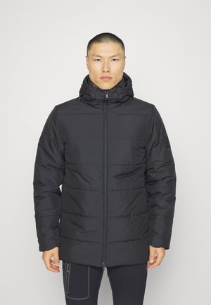 Veste matelassée noire avec fermeture éclair à l'avant, col haut et capuche. Présente des coutures matelassées horizontales et une texture lisse et mate.