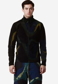 Giacca in pile con motivo astratto nero e multicolore, dotata di zip completa e colletto alto, realizzata in materiale morbido e testurizzato.