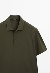 Olivově zelené polo tričko vyrobené z bavlněné tkaniny s límečkem, třemi knoflíky a krátkými rukávy. Texturovaná, jednobarevná.