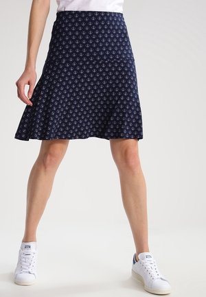 Marineblå knælange nederdel med hvide geometriske mønstre, lavet af letvægtsstof, udvidet design, kombineret med hvide sneakers.