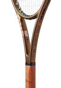 Raqueta de tenis Wilson Pro Staff con un marco negro y dorado, empuñadura texturizada y un patrón de cuerdas blanco. Presenta detalles de marca y modelo.