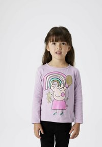 Lichtpaarse lange mouwen shirt met een cartoon varken met een regenboog, die een ballon en een teddybeer vasthoudt. Zachte stof, ronde halslijn.