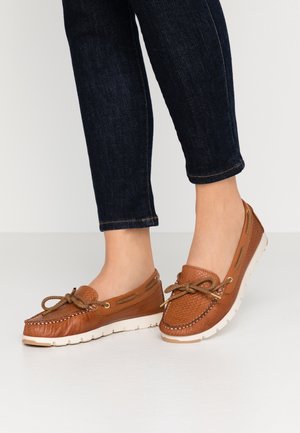 Bateau en cuir marron avec une finition texturée, bout rond et lacets à l'avant. Semelle en caoutchouc blanche et couture décorative visible.