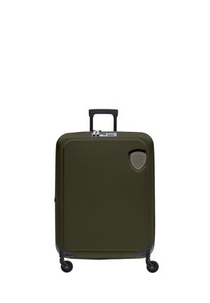 Maleta de carcasa dura color verde oliva con cuatro ruedas giratorias, asa retráctil, cremallera doble y un logo en forma de escudo de la marca en la parte frontal.
