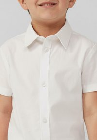 Krótki rękaw biały shirt wykonany z bawełny, z zapinaniem na guziki z przodu i wyrazistym kołnierzykiem, prezentujący subtelną fakturę i zaokrąglony dół.