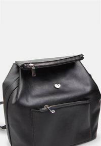 Sac à dos en cuir noir avec fermeture éclair sur le dessus, poche zippée à l'avant et texture lisse avec des accents matériels minimes.