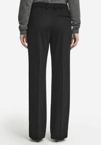 Svarta, högmidjade byxor med rak benform. Tillverkade av ett mjukt tyg, med en bakficka och bälteshällor.