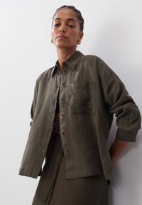 Olive green, lightweight linen shirt with a collared neckline, button front, single breast pocket, and rolled-up sleeves.
