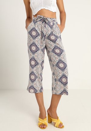 Printed cropped pants in light fabric featuring a geometric pattern in navy, pink, and cream; elastic waistband with drawstring; side pockets.