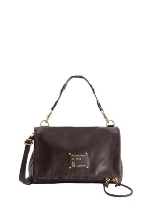 Dark brown leather handbag with a top handle, detachable shoulder strap, and a gold-lettered patch on the front flap.
