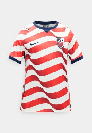 Κόκκινη και λευκή ριγέ ποδοσφαιρική φανέλα των ΗΠΑ με κυματιστές ρίγες, με σκούρο μπλε γιακά, λογότυπο Nike στο δεξί μέρος του στήθους και το έμβλημα των ΗΠΑ στο αριστερό μέρος του στήθους.