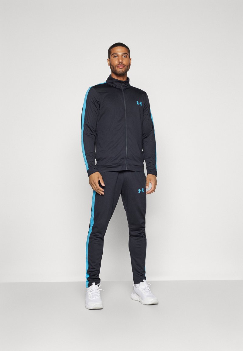 Survêtement de sport noir avec une veste zippée aux accents bleus et un pantalon assorti. Fabriqué à partir d'un tissu flexible, conçu pour le confort.
