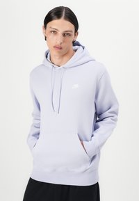 Hoodie de cor lilás claro feito de tecido suave, apresentando um bolso tipo canguru, capuz com cordão e um pequeno logótipo da Nike em branco no peito.