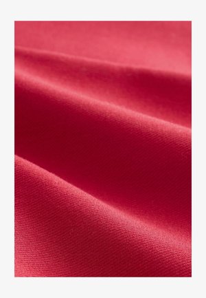 Roter Stoff mit glatter Textur, der subtile Lichtreflexionen und sanfte Falten zeigt. DieWebart ist dicht und einheitlich, was auf Qualität hinweist.