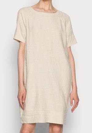 Loose-fitting, short-sleeve beige linen dress with a wide round neckline, worn by a person shown from neck to knees.