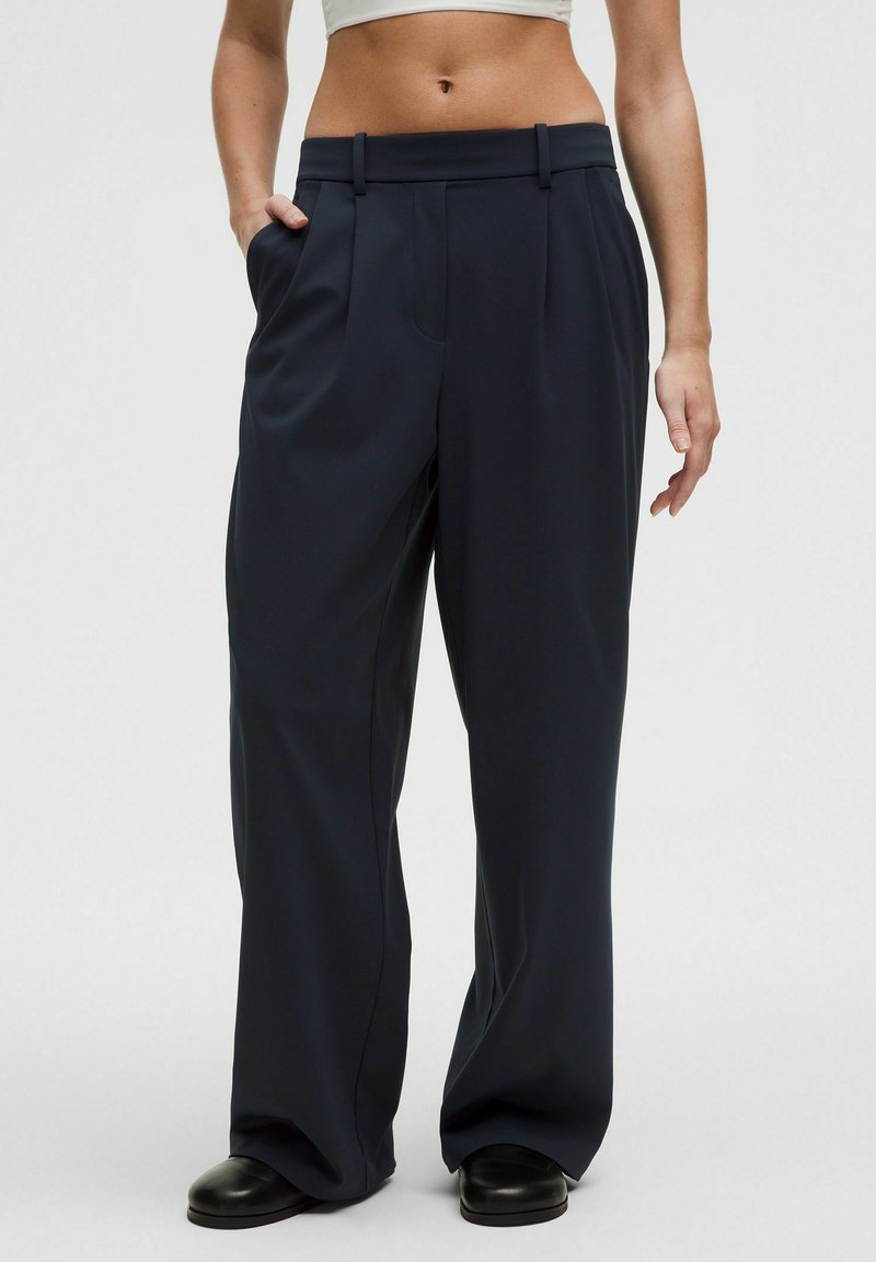 Navy wide-leg trousers made of a smooth fabric, featuring a high waist, two side pockets, and belt loops for adjustability.