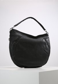 Czarna skórzana torebka o zakrzywionym kształcie, z plecionymi detalami po bokach i jedną rączką do noszenia.
