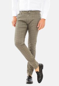 Pantaloni slim fit verde oliva chiaro con motivo a quadri, dotati di cinque tasche, passanti per la cintura e chiusura con bottone. Tessuto dalla texture liscia.