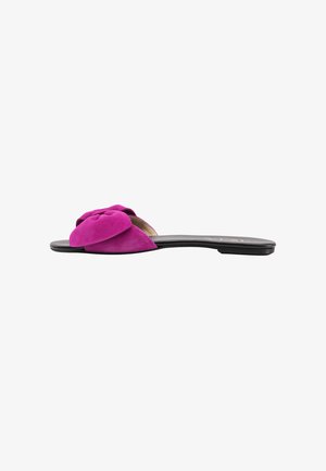 Fuchsia Wildleder-Sandale mit einer strukturierten Schleifenakzent im oberen Bereich. Schwarze Sohle, flaches Design, offene Zehen.