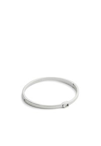 Brazalete de metal plateado con un diseño circular liso, un mecanismo de cierre simple y un logo de marca grabado.