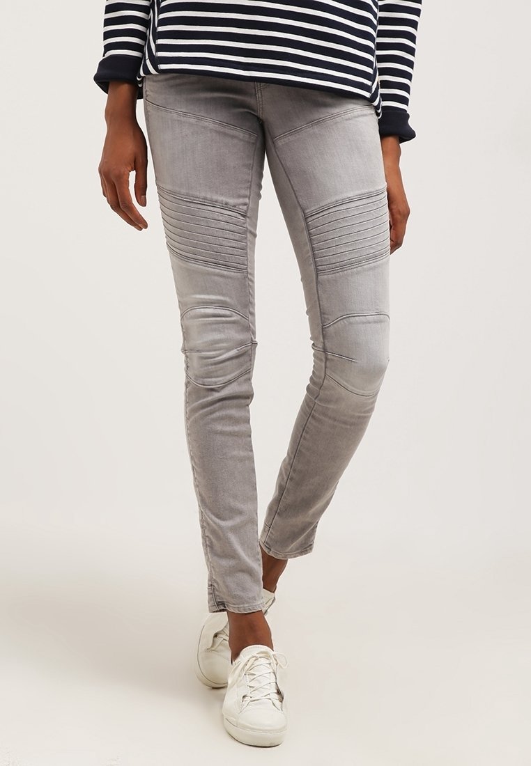 Jeans de mezclilla gris con detalles acanalados en los muslos, ajuste tapered y un ligero desvanecimiento. Combinados con zapatillas blancas para un contraste.